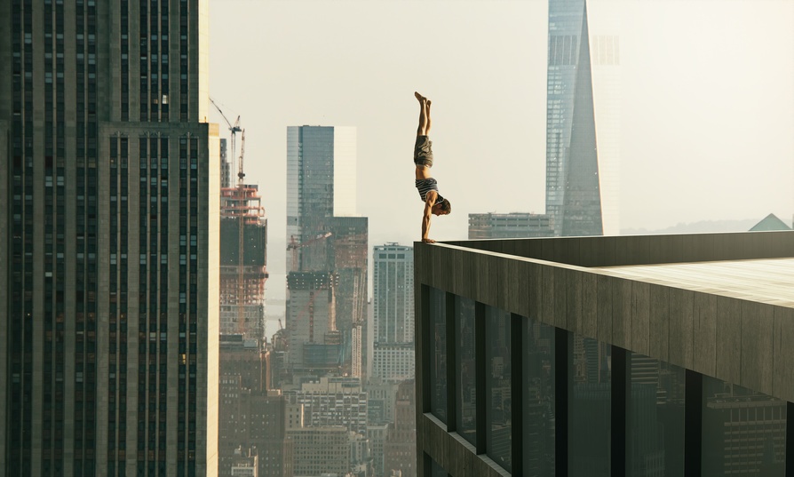 Homme en piquet tout en haut d'un immeuble. 